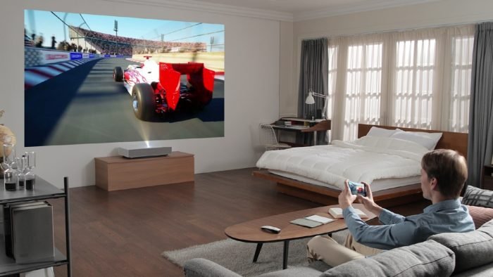 LG CineBeam 4K: A Revolução da Projeção em Alta Definição Introdução Os projetores evoluíram significativamente nos últimos anos, tornando-se uma alternativa viável às televisões para quem busca uma experiência cinematográfica em casa. A LG, uma das líderes no mercado de eletrônicos, lançou a linha LG CineBeam 4K, que promete qualidade de imagem impressionante, facilidade de instalação e uma série de recursos avançados. Neste artigo, exploraremos tudo o que você precisa saber sobre esse projetor de alta tecnologia. Design e Construção O LG CineBeam 4K apresenta um design compacto e elegante, pensado para se integrar facilmente a diferentes ambientes. Com um acabamento premium e uma estrutura leve, ele pode ser instalado em tetos, paredes ou posicionado sobre superfícies planas sem grandes dificuldades. A mobilidade é um dos seus pontos fortes, permitindo que o usuário alterne o local da projeção conforme necessário. A LG também investiu na usabilidade, trazendo um controle remoto intuitivo e um sistema de navegação amigável, facilitando o ajuste das configurações sem complicações. Qualidade de Imagem e Resolução O principal atrativo do LG CineBeam 4K é sua resolução Ultra HD (3840 x 2160), que proporciona uma nitidez impressionante. Graças à tecnologia XPR DLP, o projetor consegue reproduzir imagens em 4K real, oferecendo quatro vezes mais detalhes que um projetor Full HD. Outros destaques incluem: HDR10 e Dynamic Tone Mapping: Melhoram a reprodução de cores e contrastes, tornando as imagens mais vívidas e realistas. Brilho de até 3000 ANSI Lumens: Permite projeções nítidas mesmo em ambientes parcialmente iluminados. Taxa de Contraste Elevada: Garante pretos profundos e brancos brilhantes, essencial para uma boa experiência cinematográfica. Tamanho e Distância de Projeção Com o LG CineBeam 4K, é possível criar uma tela de até 120 polegadas sem perder qualidade. O projetor utiliza tecnologia ultra-short throw, o que significa que pode ser posicionado próximo à superfície de projeção e ainda assim gerar imagens grandes. Esse recurso é ideal para espaços pequenos, eliminando a necessidade de suportes de teto ou configurações complexas. Para quem deseja uma tela grande sem ocupar muito espaço, o CineBeam 4K é uma excelente opção. Recursos e Conectividade A LG incluiu vários recursos avançados para otimizar a experiência do usuário: Sistema Smart TV webOS: O projetor vem com a plataforma Smart TV da LG integrada, permitindo acesso direto a serviços de streaming como Netflix, YouTube, Disney+ e Amazon Prime Video sem a necessidade de um dispositivo externo. Compatibilidade com Assistentes Virtuais: O CineBeam 4K suporta comandos de voz via Google Assistente e Amazon Alexa, tornando o controle do projetor ainda mais fácil. Conexões Variadas: O projetor conta com múltiplas opções de conexão, incluindo HDMI 2.1, USB, Bluetooth e Wi-Fi, facilitando a conexão com outros dispositivos. Qualidade de Som Embora muitos projetores tenham sistemas de som fracos, a LG investiu em um sistema de alto-falantes integrados de 5W com Dolby Atmos, proporcionando um áudio envolvente sem a necessidade imediata de um sistema de som externo. Para quem deseja uma experiência ainda mais imersiva, o projetor também permite conexão com soundbars e sistemas de som sem fio via Bluetooth. Facilidade de Uso e Configuração O LG CineBeam 4K é conhecido por sua facilidade de instalação. A tecnologia de correção trapezoidal automática ajusta automaticamente a projeção para evitar distorções na imagem. Além disso, seu menu intuitivo permite que os usuários configurem rapidamente brilho, contraste e outras opções. Prós e Contras do LG CineBeam 4K Prós ✅ Resolução 4K real com suporte a HDR10. ✅ Projeção de até 120 polegadas em curta distância. ✅ Brilho elevado para ambientes variados. ✅ Sistema webOS integrado com apps de streaming. ✅ Conectividade avançada com HDMI 2.1, USB e Bluetooth. ✅ Suporte para assistentes virtuais. Contras ❌ Preço elevado em comparação com projetores convencionais. ❌ Sistema de som integrado poderia ser mais potente. ❌ Requer um ambiente controlado para melhor desempenho de imagem. Conclusão O LG CineBeam 4K é uma excelente opção para quem busca uma experiência cinematográfica em casa sem comprometer a qualidade de imagem. Com uma resolução impressionante, suporte a HDR, conectividade avançada e facilidade de uso, esse projetor se destaca no mercado. Embora tenha um preço mais alto, seus recursos justificam o investimento para quem deseja substituir uma TV de grande porte por uma solução mais flexível e imersiva. Se você está em busca de um projetor 4K de qualidade, o LG CineBeam 4K é uma escolha que vale a pena considerar.
