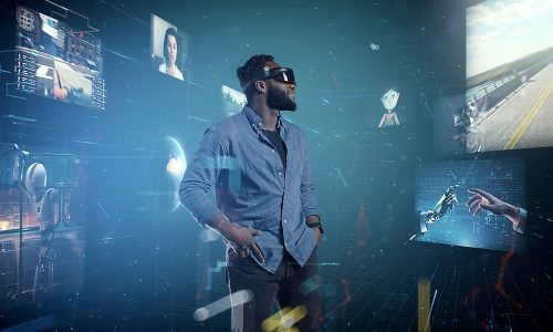 Metaverso e Realidade Estendida: A Nova Fronteira da Experiência Digital

A evolução tecnológica trouxe consigo inúmeras inovações, e uma das mais promissoras é o conceito de metaverso combinado com a realidade estendida (XR, do inglês Extended Reality). Essas tecnologias estão reconfigurando a maneira como interagimos com o mundo digital e oferecendo novas oportunidades para empresas e indivíduos. Neste artigo, vamos explorar o que é o metaverso e a realidade estendida, suas aplicações práticas, desafios e as tendências futuras que estão moldando essa nova fronteira digital.

O Que é o Metaverso?

O metaverso é um universo virtual compartilhado, acessado através da internet, onde os usuários podem interagir entre si e com um ambiente digital por meio de avatares personalizados. Esse conceito ganhou popularidade graças a empresas como Facebook (agora Meta), que estão investindo pesadamente na criação de plataformas imersivas e interativas.

Realidade Estendida (XR)

A realidade estendida é um termo abrangente que engloba as tecnologias de Realidade Aumentada (AR), Realidade Virtual (VR) e Realidade Mista (MR).

Realidade Aumentada (AR): A AR sobrepõe elementos digitais ao mundo real, aprimorando a percepção do usuário com informações adicionais.

Realidade Virtual (VR): A VR cria um ambiente digital totalmente imersivo, onde os usuários podem explorar e interagir com um mundo virtual.

Realidade Mista (MR): A MR combina elementos de AR e VR, permitindo a interação entre objetos do mundo real e digital em tempo real.

Aplicações Práticas do Metaverso e XR

Entretenimento e Jogos: O setor de jogos é um dos primeiros a adotar o metaverso e XR, oferecendo experiências imersivas que vão além das telas tradicionais.

Educação e Treinamento: A realidade estendida está revolucionando a educação, proporcionando aulas interativas, simulações de treinamento e ambientes de aprendizagem imersivos.

Saúde: Médicos e terapeutas estão utilizando XR para treinamento, cirurgias remotas e tratamentos psicológicos, como terapia de exposição para fobias.

Comércio e Varejo: Empresas estão criando lojas virtuais onde os clientes podem experimentar produtos digitalmente antes de comprá-los.

Colaboração e Trabalho Remoto: Plataformas de metaverso oferecem espaços virtuais de trabalho onde equipes podem se reunir, colaborar e realizar reuniões de maneira mais interativa e eficiente.

Turismo e Imobiliário: Agências de turismo e imobiliárias estão oferecendo tours virtuais de destinos e propriedades, permitindo que os clientes explorem antes de tomar decisões.

Benefícios do Metaverso e XR

Interatividade e Imersão: O metaverso e XR proporcionam uma experiência muito mais interativa e imersiva do que as tecnologias tradicionais, aumentando o engajamento dos usuários.

Acessibilidade: Com a realidade estendida, pessoas de qualquer lugar do mundo podem acessar experiências e informações que antes eram inacessíveis.

Eficiência e Economia: Empresas podem economizar tempo e recursos utilizando XR para treinamento, design e colaboração virtual.

Inovação Contínua: As tecnologias de metaverso e XR estão constantemente evoluindo, oferecendo novas ferramentas e oportunidades para inovação.

Desafios e Considerações

Privacidade e Segurança: A coleta e uso de dados pessoais em ambientes virtuais levantam preocupações sobre privacidade e segurança.

Custo de Entrada: O desenvolvimento e a implementação de tecnologias de XR podem ser caros, o que pode ser um obstáculo para algumas empresas.

Infraestrutura Tecnológica: A criação de experiências de metaverso e XR requer uma infraestrutura tecnológica robusta, incluindo internet de alta velocidade e dispositivos de ponta.

Adoção e Inclusão: Garantir que essas tecnologias sejam acessíveis e inclusivas para todos é um desafio contínuo.

Tendências Futuras do Metaverso e XR

Interoperabilidade: A criação de padrões e protocolos que permitem a interação entre diferentes plataformas de metaverso será crucial para a expansão dessa tecnologia.

Integração com IA e Machine Learning: A combinação de metaverso e XR com IA permitirá experiências mais personalizadas e interativas, como avatares inteligentes e ambientes adaptativos.

Desenvolvimento de Hardware: O avanço em dispositivos de XR, como óculos e luvas hápticas, melhorará a imersão e a interatividade.

Economia Virtual: A criação de economias dentro do metaverso, com moedas digitais e mercados virtuais, permitirá novas formas de comércio e geração de renda.

Sustentabilidade: Desenvolver tecnologias de metaverso e XR que sejam energeticamente eficientes e sustentáveis será uma prioridade para mitigar o impacto ambiental.

Conclusão

O metaverso e a realidade estendida estão na vanguarda da transformação digital, oferecendo uma vasta gama de aplicações e oportunidades para inovação. Enquanto enfrentamos desafios significativos, as tendências futuras indicam um potencial quase ilimitado para essas tecnologias moldarem o futuro da interação humana. Empresas e indivíduos que adotarem e explorarem essas novas fronteiras estarão bem posicionados para aproveitar os benefícios e liderar na era digital.

À medida que o metaverso e a realidade estendida continuam a evoluir, é essencial manter-se atualizado com as últimas tendências e desenvolvimentos.
