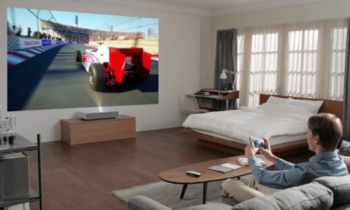 LG CineBeam 4K: A Revolução da Projeção em Alta Definição

Introdução

Os projetores evoluíram significativamente nos últimos anos, tornando-se uma alternativa viável às televisões para quem busca uma experiência cinematográfica em casa. A LG, uma das líderes no mercado de eletrônicos, lançou a linha LG CineBeam 4K, que promete qualidade de imagem impressionante, facilidade de instalação e uma série de recursos avançados. Neste artigo, exploraremos tudo o que você precisa saber sobre esse projetor de alta tecnologia.

Design e Construção

O LG CineBeam 4K apresenta um design compacto e elegante, pensado para se integrar facilmente a diferentes ambientes. Com um acabamento premium e uma estrutura leve, ele pode ser instalado em tetos, paredes ou posicionado sobre superfícies planas sem grandes dificuldades. A mobilidade é um dos seus pontos fortes, permitindo que o usuário alterne o local da projeção conforme necessário.

A LG também investiu na usabilidade, trazendo um controle remoto intuitivo e um sistema de navegação amigável, facilitando o ajuste das configurações sem complicações.

Qualidade de Imagem e Resolução

O principal atrativo do LG CineBeam 4K é sua resolução Ultra HD (3840 x 2160), que proporciona uma nitidez impressionante. Graças à tecnologia XPR DLP, o projetor consegue reproduzir imagens em 4K real, oferecendo quatro vezes mais detalhes que um projetor Full HD.

Outros destaques incluem:

HDR10 e Dynamic Tone Mapping: Melhoram a reprodução de cores e contrastes, tornando as imagens mais vívidas e realistas.

Brilho de até 3000 ANSI Lumens: Permite projeções nítidas mesmo em ambientes parcialmente iluminados.

Taxa de Contraste Elevada: Garante pretos profundos e brancos brilhantes, essencial para uma boa experiência cinematográfica.

Tamanho e Distância de Projeção

Com o LG CineBeam 4K, é possível criar uma tela de até 120 polegadas sem perder qualidade. O projetor utiliza tecnologia ultra-short throw, o que significa que pode ser posicionado próximo à superfície de projeção e ainda assim gerar imagens grandes.

Esse recurso é ideal para espaços pequenos, eliminando a necessidade de suportes de teto ou configurações complexas. Para quem deseja uma tela grande sem ocupar muito espaço, o CineBeam 4K é uma excelente opção.

Recursos e Conectividade

A LG incluiu vários recursos avançados para otimizar a experiência do usuário:

Sistema Smart TV webOS: O projetor vem com a plataforma Smart TV da LG integrada, permitindo acesso direto a serviços de streaming como Netflix, YouTube, Disney+ e Amazon Prime Video sem a necessidade de um dispositivo externo.

Compatibilidade com Assistentes Virtuais: O CineBeam 4K suporta comandos de voz via Google Assistente e Amazon Alexa, tornando o controle do projetor ainda mais fácil.

Conexões Variadas: O projetor conta com múltiplas opções de conexão, incluindo HDMI 2.1, USB, Bluetooth e Wi-Fi, facilitando a conexão com outros dispositivos.

Qualidade de Som

Embora muitos projetores tenham sistemas de som fracos, a LG investiu em um sistema de alto-falantes integrados de 5W com Dolby Atmos, proporcionando um áudio envolvente sem a necessidade imediata de um sistema de som externo.

Para quem deseja uma experiência ainda mais imersiva, o projetor também permite conexão com soundbars e sistemas de som sem fio via Bluetooth.

Facilidade de Uso e Configuração

O LG CineBeam 4K é conhecido por sua facilidade de instalação. A tecnologia de correção trapezoidal automática ajusta automaticamente a projeção para evitar distorções na imagem. Além disso, seu menu intuitivo permite que os usuários configurem rapidamente brilho, contraste e outras opções.

Prós e Contras do LG CineBeam 4K

Prós

✅ Resolução 4K real com suporte a HDR10.
✅ Projeção de até 120 polegadas em curta distância.
✅ Brilho elevado para ambientes variados.
✅ Sistema webOS integrado com apps de streaming.
✅ Conectividade avançada com HDMI 2.1, USB e Bluetooth.
✅ Suporte para assistentes virtuais.

Contras

❌ Preço elevado em comparação com projetores convencionais.
❌ Sistema de som integrado poderia ser mais potente.
❌ Requer um ambiente controlado para melhor desempenho de imagem.

Conclusão

O LG CineBeam 4K é uma excelente opção para quem busca uma experiência cinematográfica em casa sem comprometer a qualidade de imagem. Com uma resolução impressionante, suporte a HDR, conectividade avançada e facilidade de uso, esse projetor se destaca no mercado.

Embora tenha um preço mais alto, seus recursos justificam o investimento para quem deseja substituir uma TV de grande porte por uma solução mais flexível e imersiva. Se você está em busca de um projetor 4K de qualidade, o LG CineBeam 4K é uma escolha que vale a pena considerar.